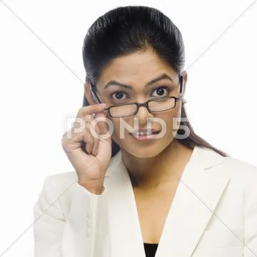 Portrait of a curious businesswoman holding her eyeglasses Stock Photos