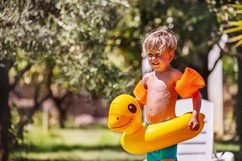 Portrait of cute blond boy with floaties ready for summer fun Stock Photos