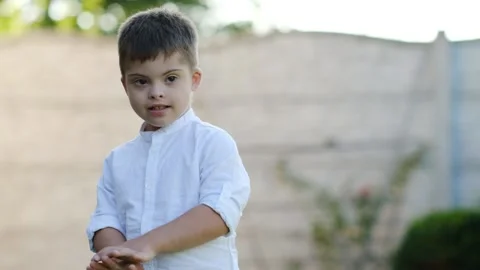 Portrait of a cute boy with disabilities, Down syndrome Stock Footage 165042774