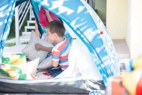 Portrait of cute boy inside tent at backyard Stock Photos
