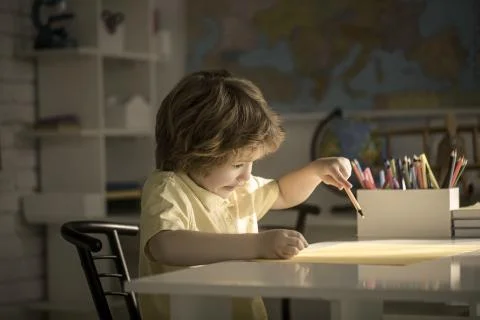 Portrait of a cute boy learning in the classroom on the table. Stock Photos
