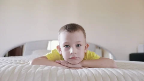 Portrait of a cute boy lying on the bed. Morning. Stock Footage 156300896