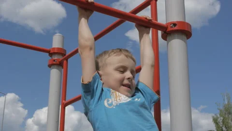 Portrait of cute boy performing pull-ups on bar in summer Stock-Footage 156068947