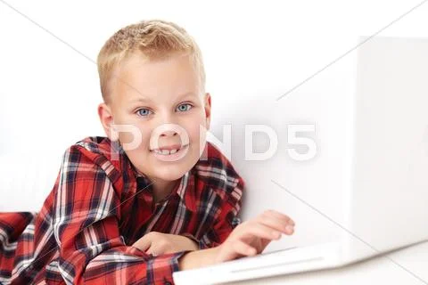 Portrait of cute boy typing and looking at camera Stock Photos