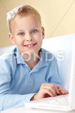 Portrait of cute boy typing and looking at camera Stock Photos