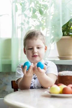 Portrait of a cute child with Easter eggs. Easter lunch. The feast of Holy Ea Stock Photos
