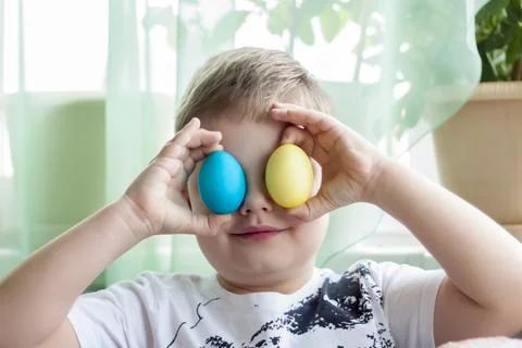 Portrait of a cute child with Easter eggs. Easter lunch. The feast of Holy Ea Stock Photos