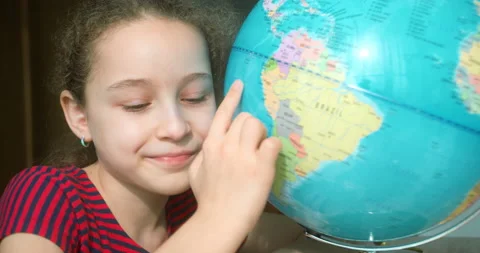 Portrait Cute Child looking at camera smiling holding globe next to him Stock Footage 237722693