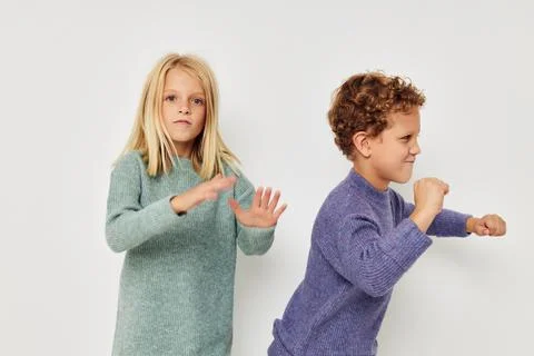 Portrait of cute children in multi-colored sweaters posing for fun light Stock Photos