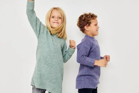 Portrait of cute children in multi-colored sweaters posing for fun childhood Stock Photos