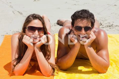 Portrait of a cute couple being tanning on the beach Stock Photos