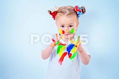 A portrait of a cute girl in colorful paints. Childhood, leisure activities. Stock Photos