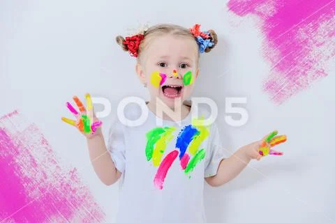 A portrait of a cute girl in colorful paints. Childhood, leisure activities. Stock Photos
