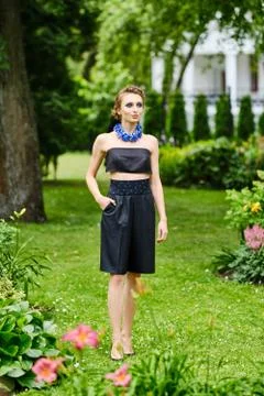 Portrait of cute girl in small topic blouse and breeches walking near the flo Foto stock