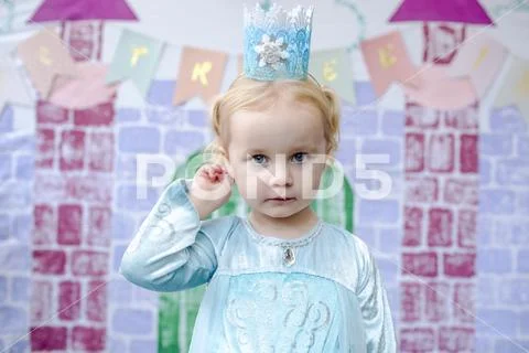 Portrait of cute girl standing against castle painting during princess party Stock Photos