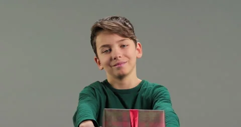 Portrait of cute kid giving a present box to camera isolated Stock Footage 286706121