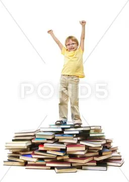 Portrait of cute kid standing on pile of books with raised arms Stock Photos