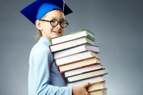 Portrait of cute lad with stack of books looking at camera Stockfoto's