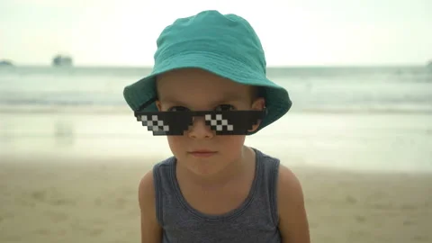 Portrait of cute little boy in straw hat with sunglasses standing on summer Vídeo Stock 106897953