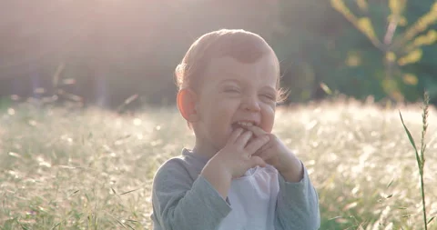 Portrait of a cute one year old boy in spring park at sunset Stock Footage 108974997