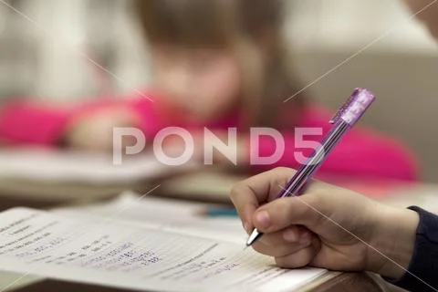 Portrait of cute pretty little serious child girl drawing with pencil on pape Stock Photos
