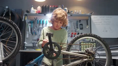 Portrait of cute small child fixing bike parts with tools in modern authentic Stock Footage 232493557