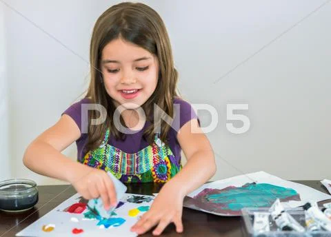 Portrait of a cute smiling girl painting a picture Stock Photos