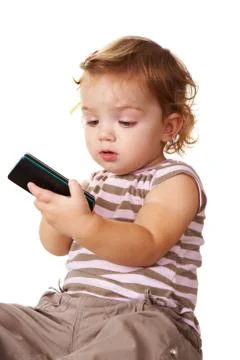 Portrait of cute toddler looking at cellular phone in her hands Stock Photos