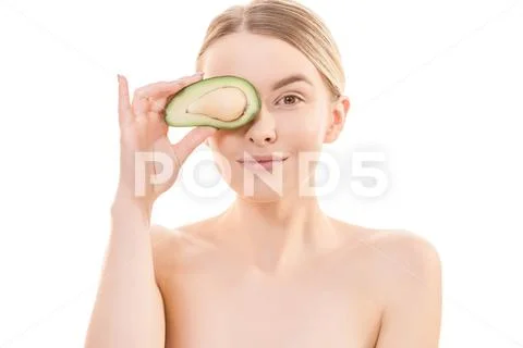 The portrait of the cute woman with an avocado on the white background Stock Photos