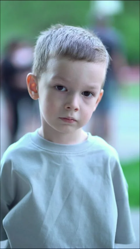 Portrait of a cute young boy with short hair and serious thoughtful expression Видео 336964319