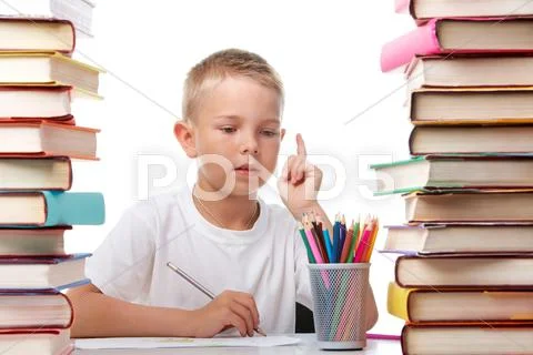 Portrait of cute youngster sitting among stacks of books and thinking while draw Stock Photos