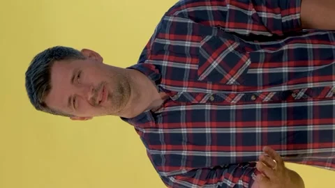 Portrait of dark-haired man in checkered shirt showing negative feelings and Stock Footage 130176356