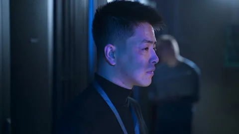 Portrait of data engineer checking equipment and hardware, standing in dark Stock Footage 164910662