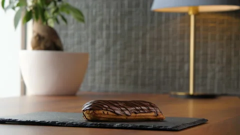 Portrait of a delicious eclair covered with chocolate glaze 스톡 동영상 168188478