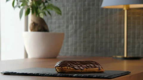 Portrait of a delicious eclair covered with chocolate glaze 库存影片 168188683