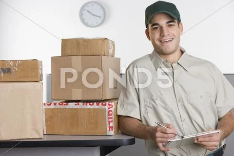 Portrait Of Delivery Man With Stack Of Boxes