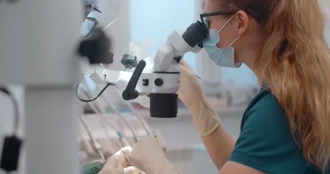 Portrait of the dental surgeon using the microscope during the surgery in dental Stock Footage 267397438