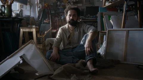 Portrait of Depressed Painter Sitting among Broken Artworks in Studio Stock Footage 334682067
