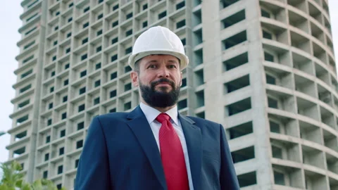 A portrait of a design engineer in a white safety helmet in a business suit with Stock Footage 163228262