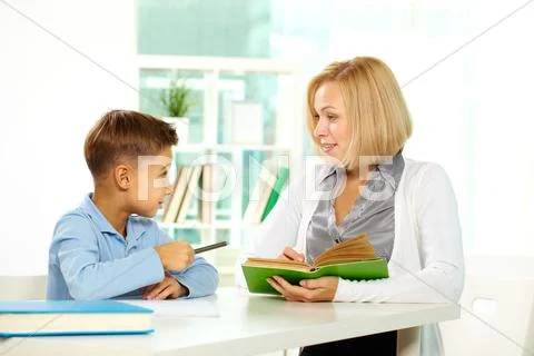 Portrait of diligent boy and his tutor interacting with each other Stock Photos