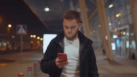 Portrait of disappointed young man learning bad news on smartphone raising hands Stock Footage 117429745