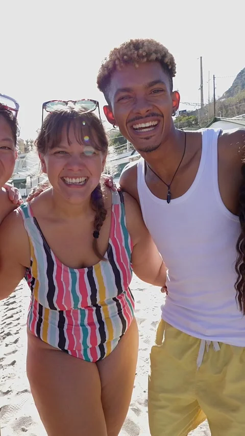 Portrait of diverse friends looking at camera hugging each other at beach Stock Footage 277468028