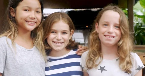 Portrait of diverse group of three young girls smiling and looking at the camera Stock Footage 85373504