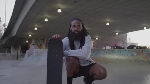 Portrait of Diverse Man with Dreadlocks and Beard Holding Skateboard at Downtown Video stock 270399948