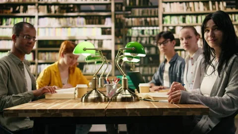 Portrait of diverse students and tutor in group study together at library table Stock Footage 336357964