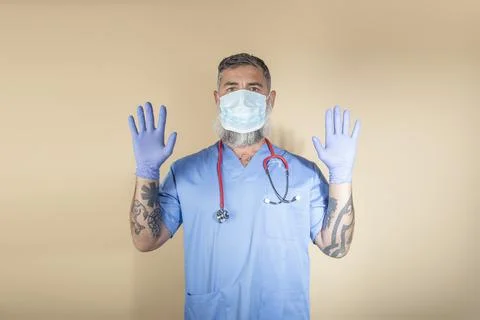 Portrait of doctor gesturing while standing against wall background.Health wo Stock Photos