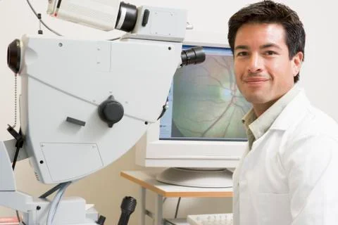Portrait Of A Doctor Next To An Eye Exam Machine Stock Photos