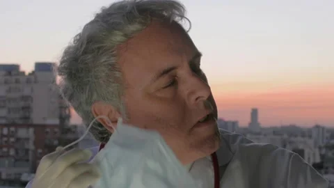 Portrait Doctor removing face mask in sunset Hero against coronavirus COVID 19 Stock Footage 131456853
