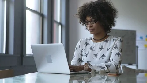 Portrait dolly shot of businesswoman using laptop computer while working at desk Stock Footage