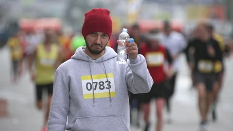 Portrait of drinking water and looking at camera sportsman on marathon event. Stock Footage 166494756